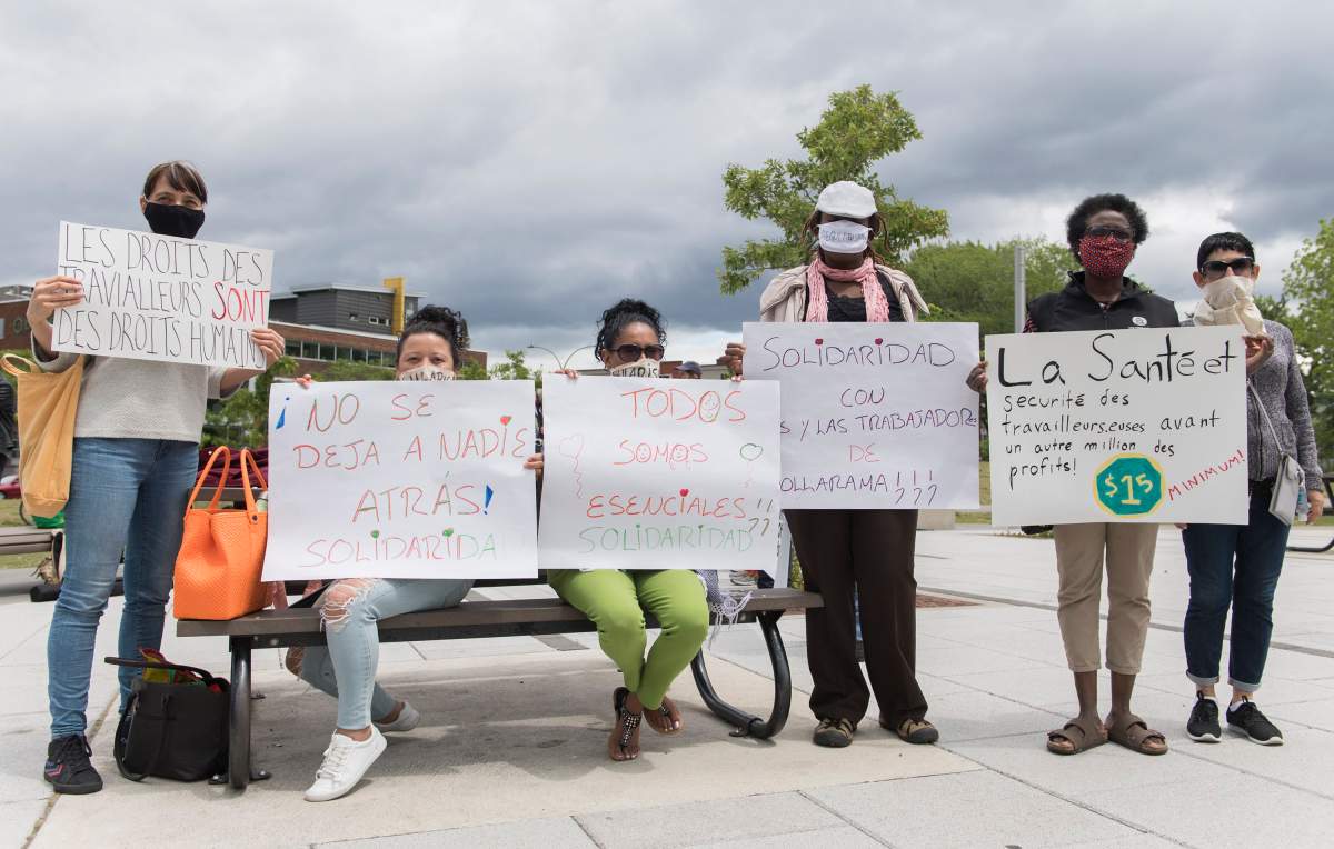 Dollarama workers hold up signs during a protest calling for better pay and working conditions in Montreal, Saturday, June 13, 2020, as the COVID-19 pandemic continues in Canada and around the world. 