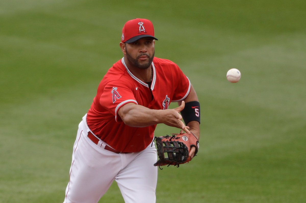 FILE - In this Feb. 28, 2020, file photo, Los Angeles Angels first baseman Albert Pujols throws the ball during the fourth inning of a spring training baseball game against the Texas Rangers in Tempe, Ariz.