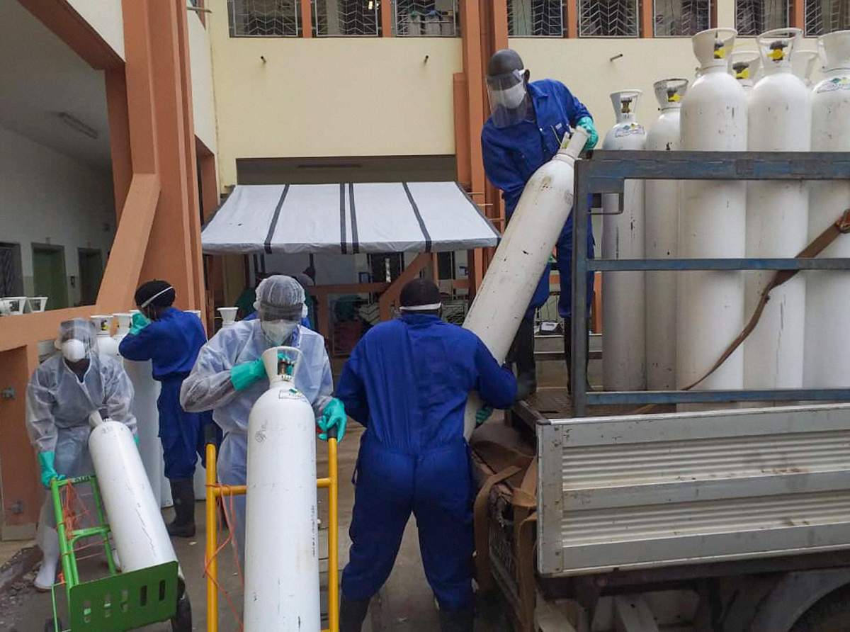 Medical workers offload cylinders of oxygen at the Donka public hospital where coronavirus patients are treated in Conakry, Guinea, on Wednesday, May 20, 2020.