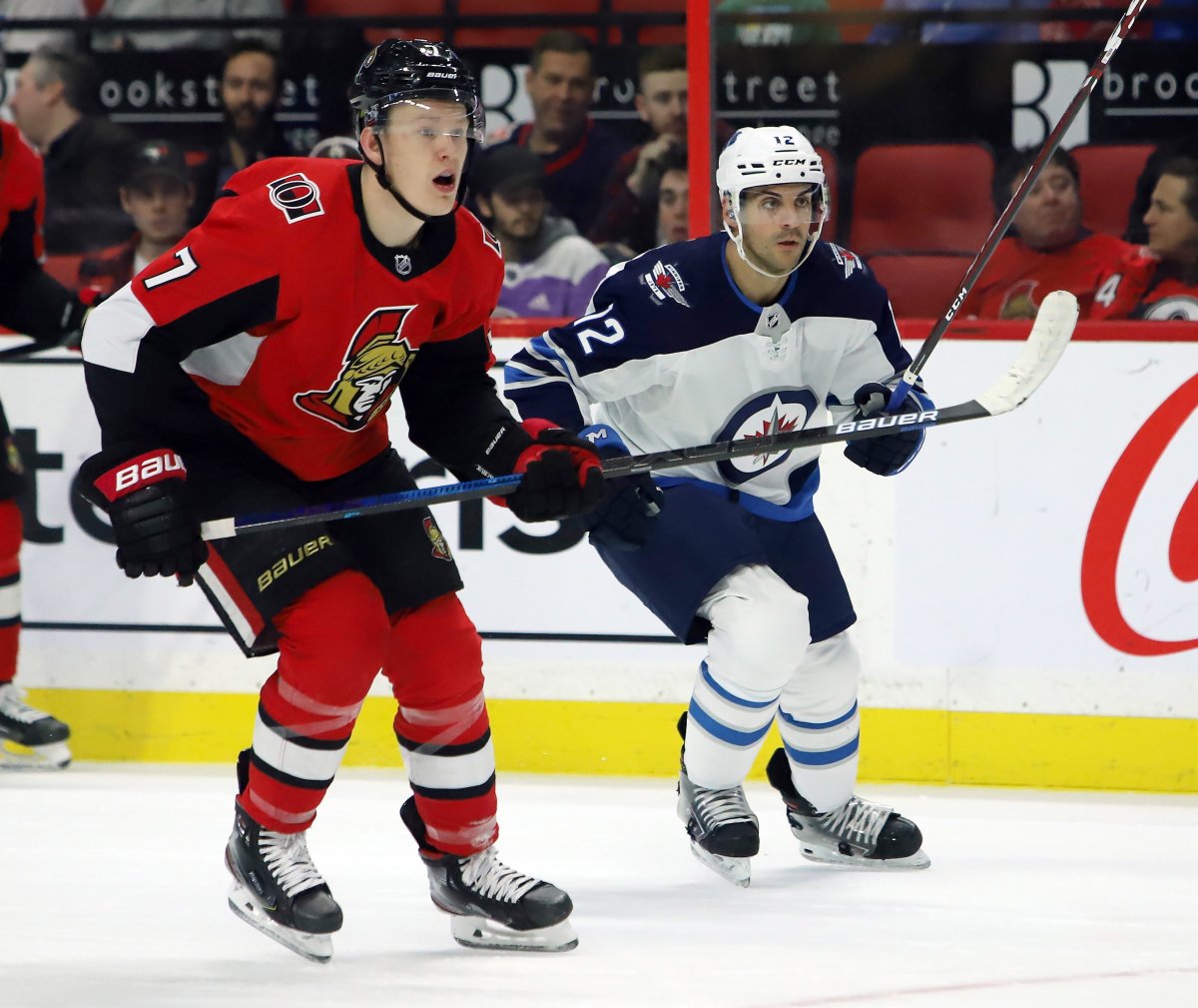 Winnipeg Jets defenceman Dylan DeMelo (12) and Ottawa Senators left wing Brady Tkachuk (7) look down ice towards the play during second period NHL action in Ottawa on Thursday, Feb. 20, 2020. The Senators are hoping for some good luck when the first phase of the 2020 NHL Draft Lottery goes on Friday. 