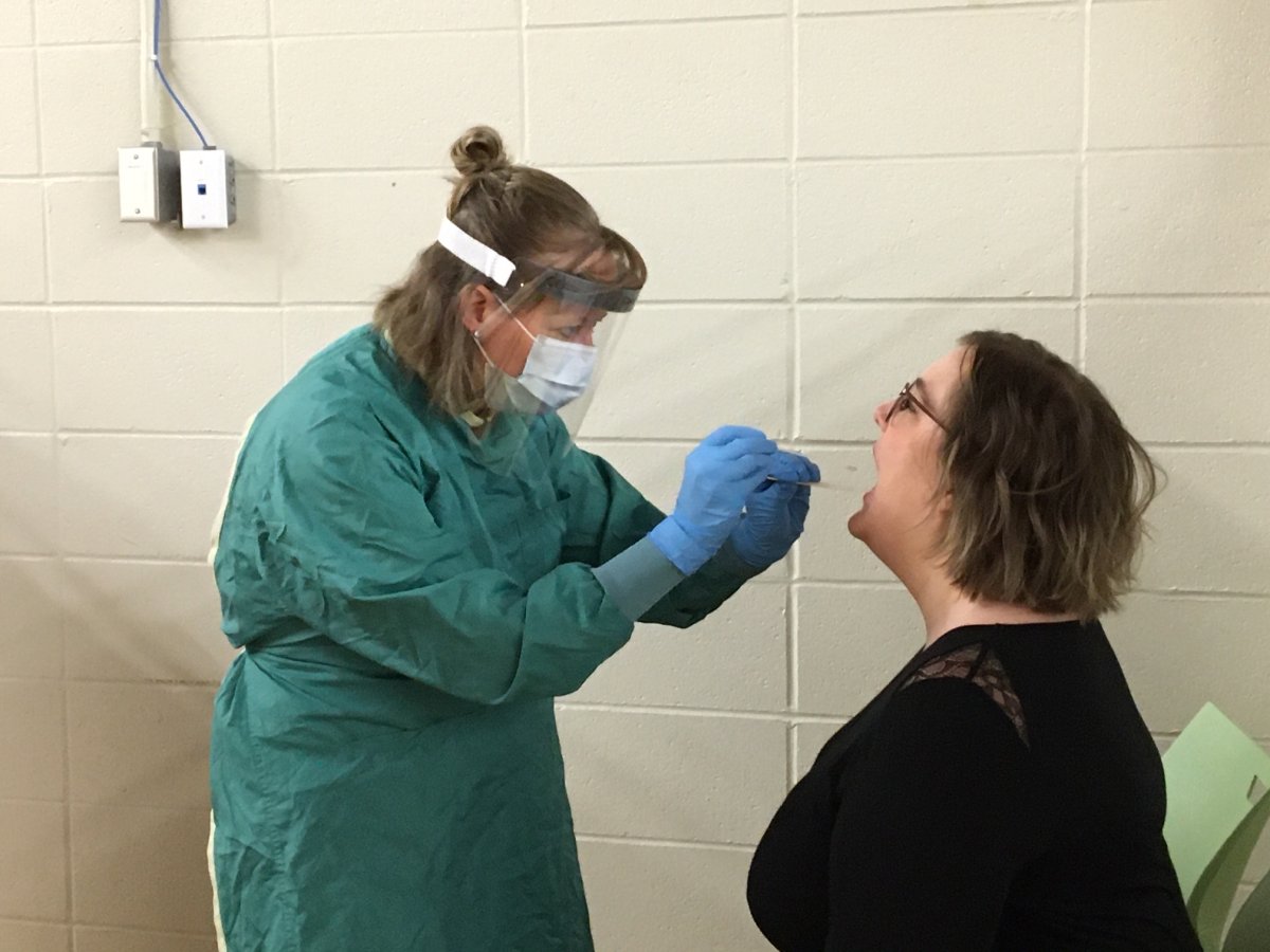 Registered Nurse Jocelyn Tews administers a throat swab to test for COVID-19.