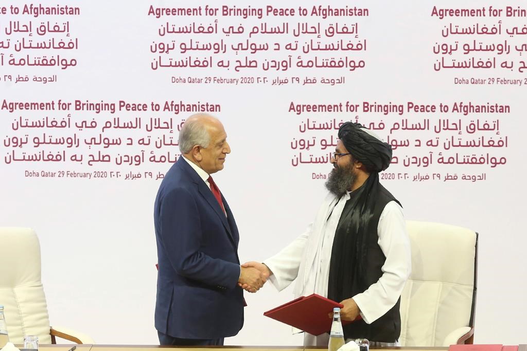 FILE - In this Feb. 29, 2020 file photo, U.S. peace envoy Zalmay Khalilzad, left, and Mullah Abdul Ghani Baradar, the Taliban group's top political leader shake hands after signing a peace agreement between Taliban and U.S. officials in Doha, Qatar.