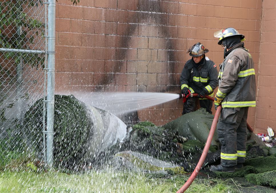 Amherst firefighters pour foam onto a fire that occurred in some artificial turf that was stored behind the Amherst Stadium on Saturday, June 13, 2020.