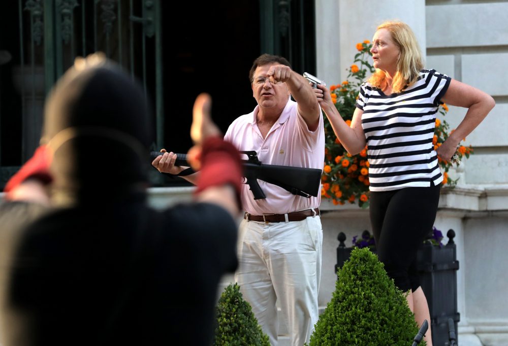 Armed homeowners standing in front their house along Portland Place confront protesters marching to St. Louis Mayor Lyda Krewson's house Sunday, June 28, 2020, in the central west end of St. Louis.