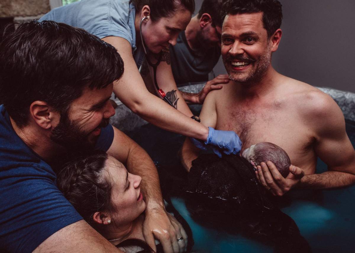 Brandon Overland holds his daughter, Quinn, after she was born in Manitoba with help of surrogate Brianna Darbel.