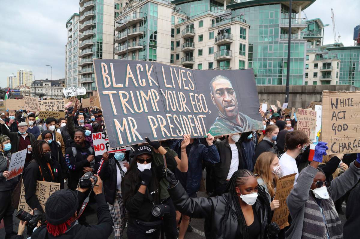 People take part in a Black Lives Matter protest rally outside the U.S. Embassy, in London, Sunday June 7, 2020, in response to the recent killing of George Floyd at the hands of police in Minneapolis that has led to protests in many countries and across the U.S.