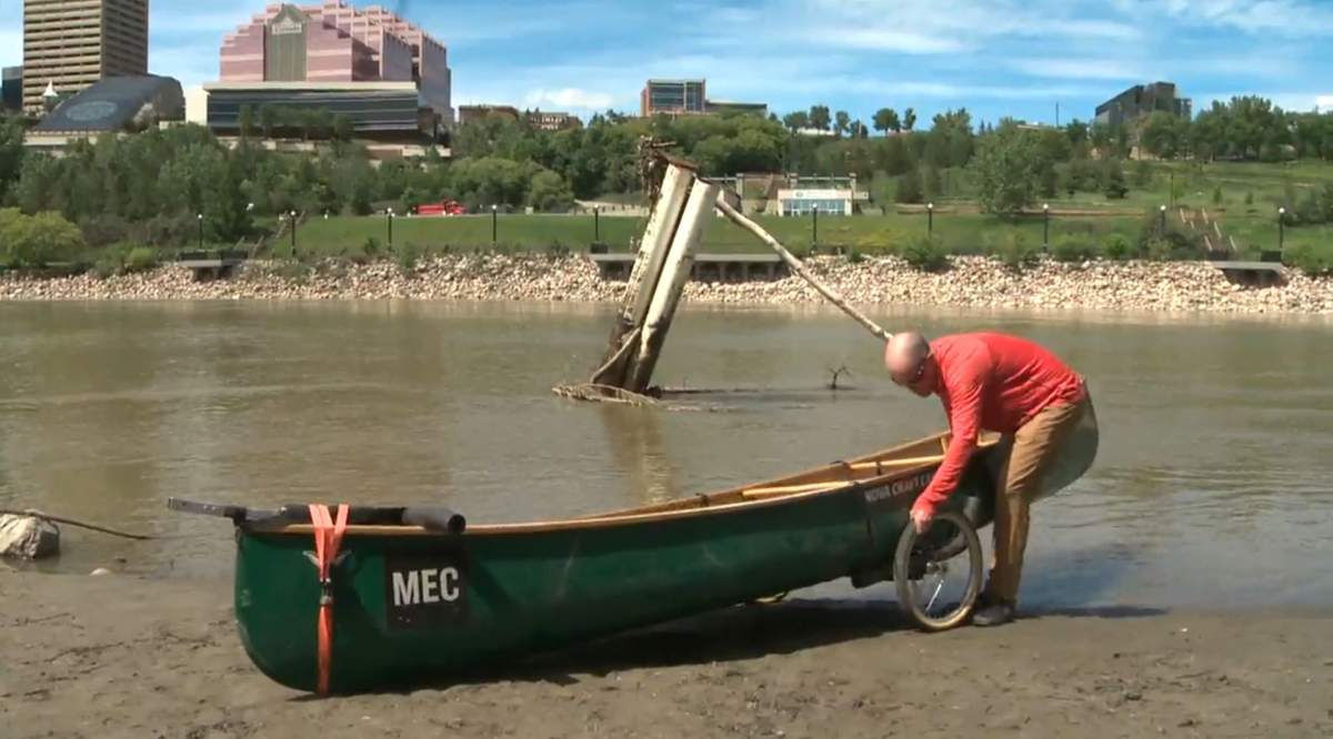 Dr. Darren Markland taking off his portage to put canoe in water on the North Saskatchewan River, in Edmonton, Alta., Tuesday June 23.