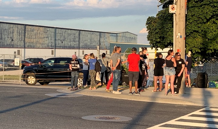 Residents gather outside of the Fearman's pork facility in Burlington Friday evening.