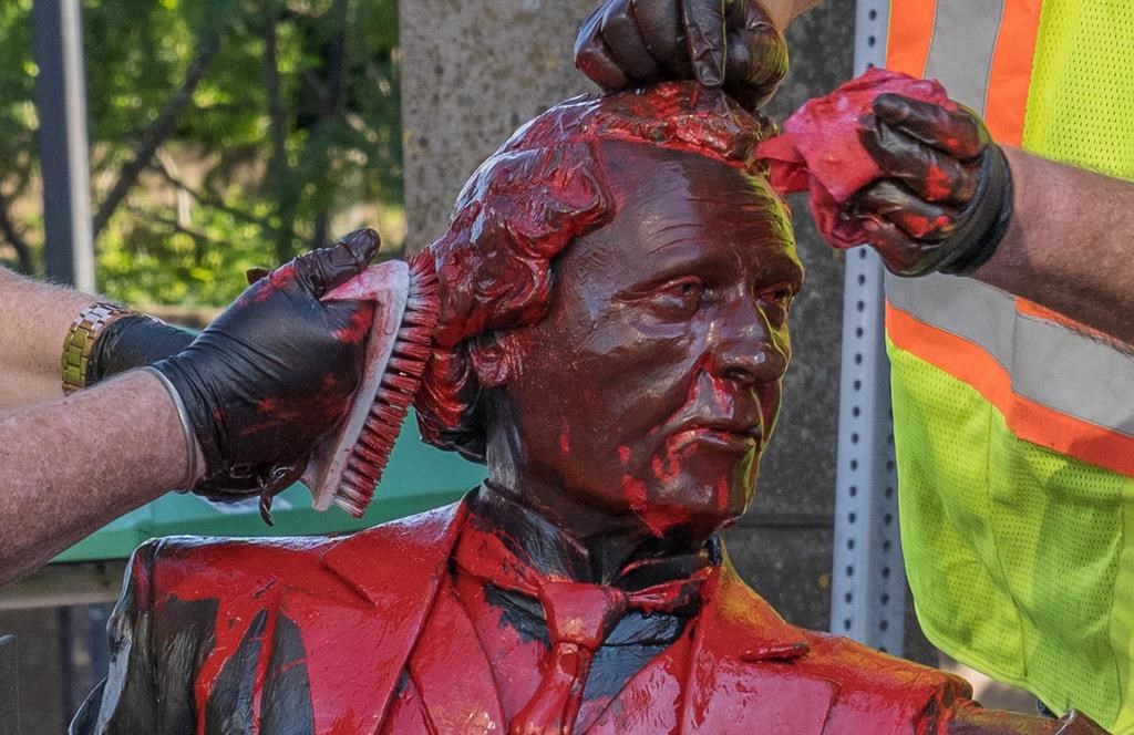 Workers remove red paint from a Sir John A. Macdonald statue in Charlottetown on Friday June 19, 2020.