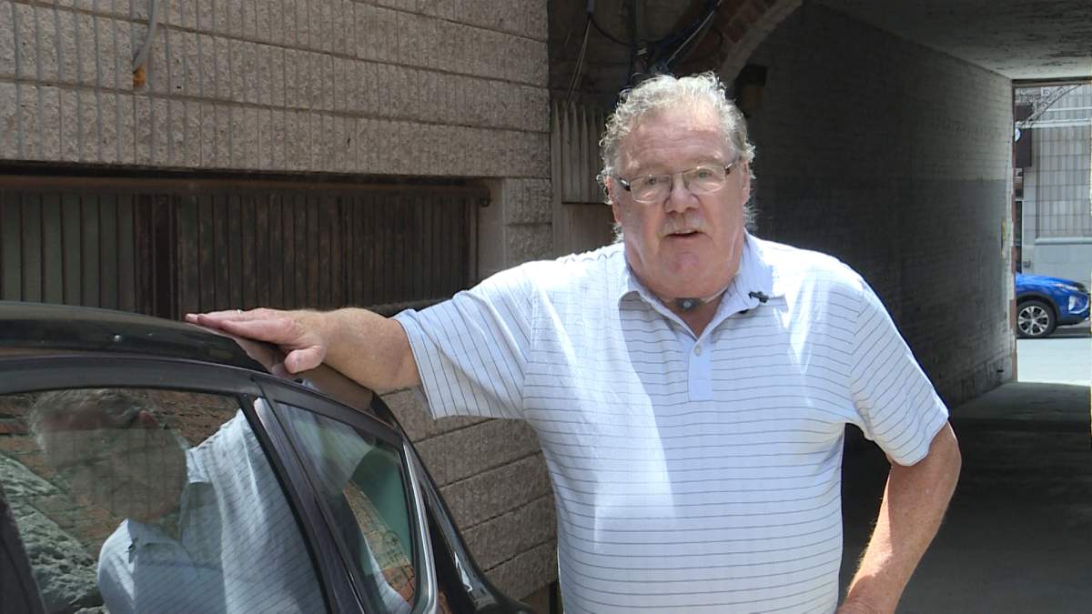 Terry Whyte stands next to his car in his driveway