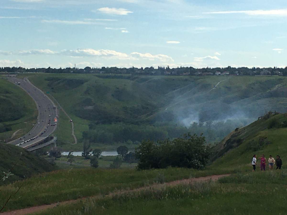 Smoke rises from a brush fire in the Oldman river valley in Lethbridge on June 22.