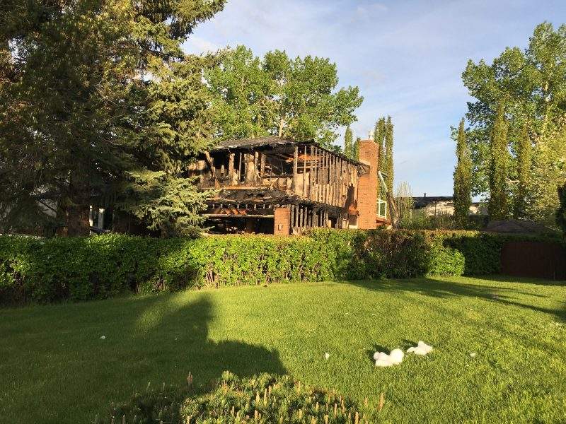 Extensive damage is visible after a fire engulfed a house in the 5900 block of Dalcastle Drive Northwest in Calgary, Alta., on Thursday, June 4, 2020.