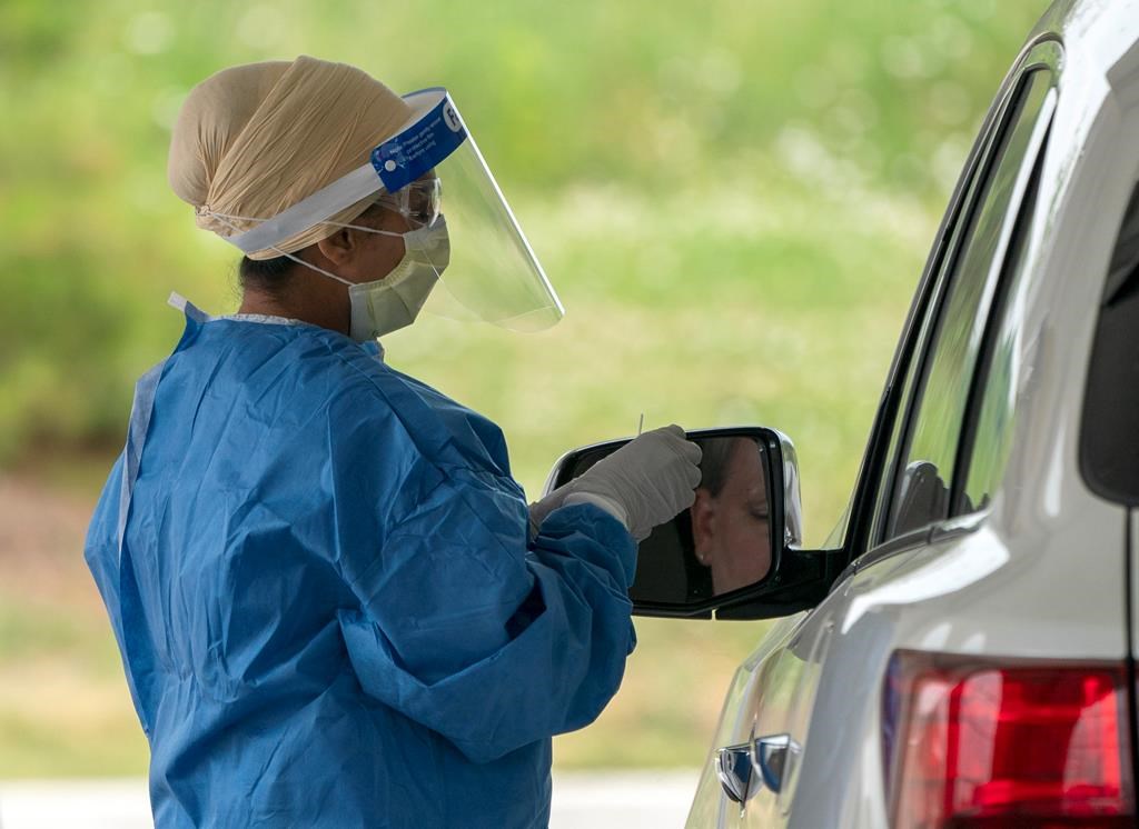 A nurse prepares to do a COVID-19 test at the drive through centre at Etobicoke General Hospital on Monday, June 22, 2020. THE CANADIAN PRESS/Frank Gunn.