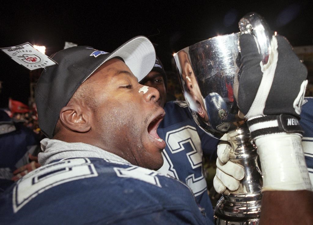 Baltimore Stallions' Mike Pringle prepares to give the Grey Cup a kiss following the Stallions' victory over the Calgary Stampeders, in Regina, Nov 19, 1995. Twenty-five years ago, the star running back helped Baltimore become the first -- and only -- American franchise to capture the Grey Cup. THE CANADIAN PRESS/Tom Hanson.
