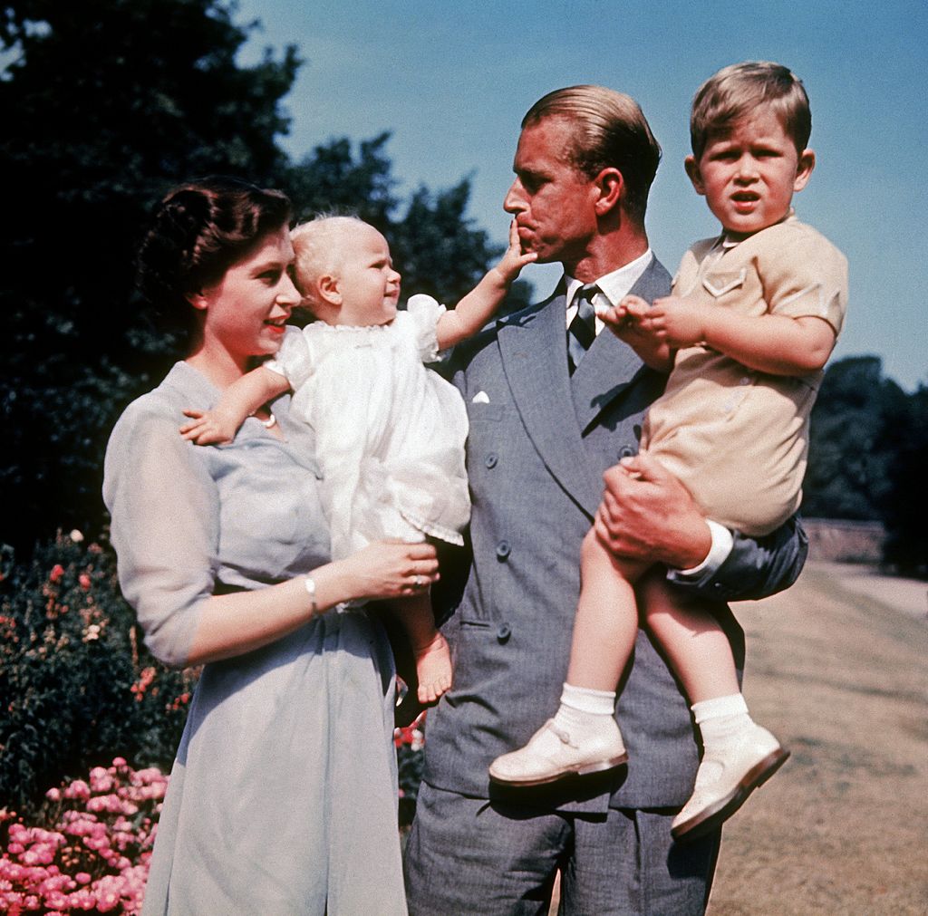 The first colour photograph of Princess Anne, taken in 1951, in the arms of her mother Queen Elizabeth II while her father, Philip Mountbatten, holds her brother Prince Charles.