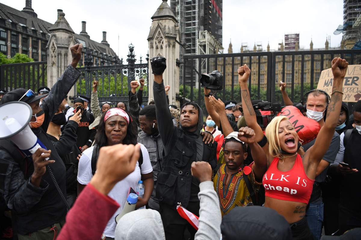 Protestors, including British actor John Boyega, raise their fists in Parliament square during an anti-racism demonstration in London, on June 3, 2020, after George Floyd, an unarmed black man died after a police officer knelt on his neck during an arrest in Minneapolis, Minn., on May 25, 2020.