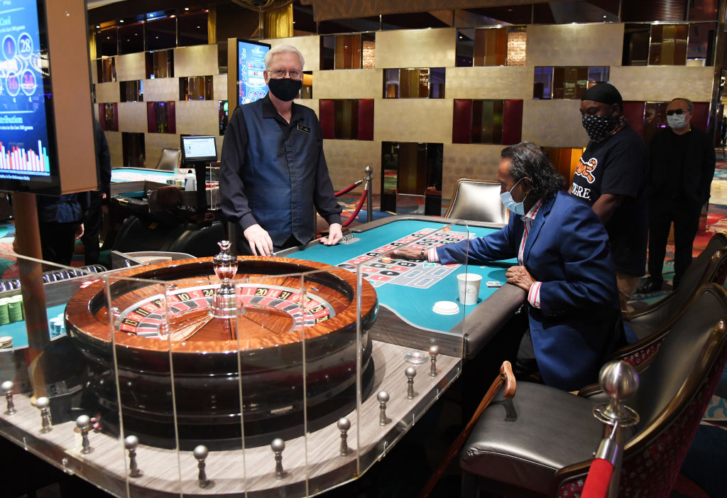 Dealer Gary Reed looks on as Tilak Fernando and Dred Phillips play roulette at Bellagio Resort & Casino on the Las Vegas Strip after the property opened for the first time since being closed on March 17 because of the coronavirus (COVID-19) pandemic on June 4, 2020 in Las Vegas, Nevada. 