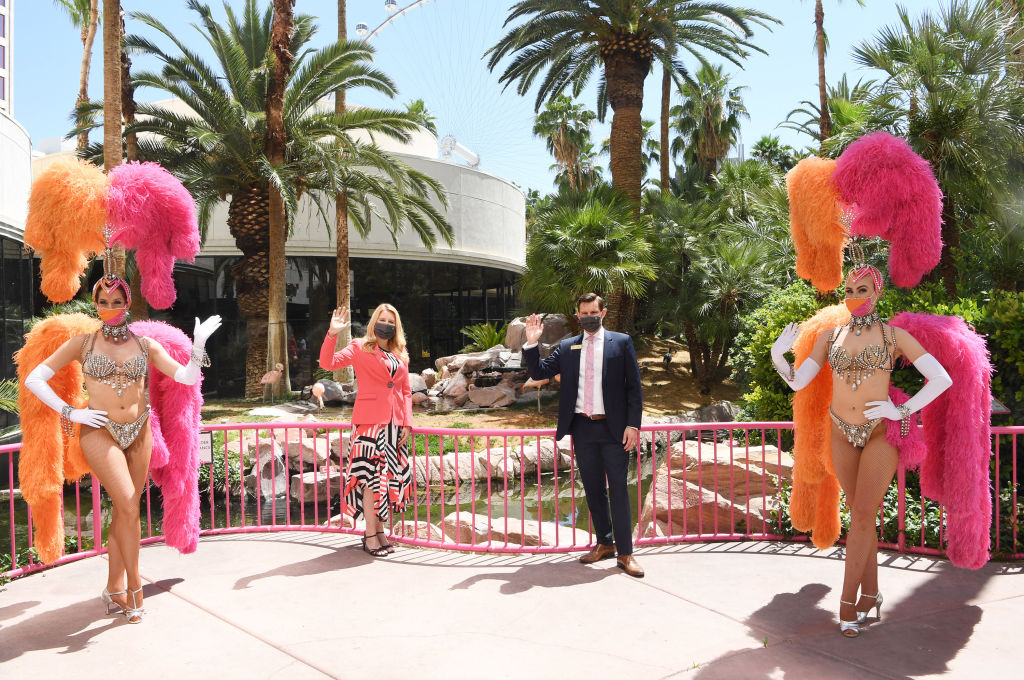 Caesars Entertainment Regional President Eileen Moore (2nd L), and GM of Flamingo Las Vegas Ken Janssen (3rd L) pose for photos with two showgirls at the reopening of Flamingo Las Vegas on June 4 in Las Vegas, Nevada.