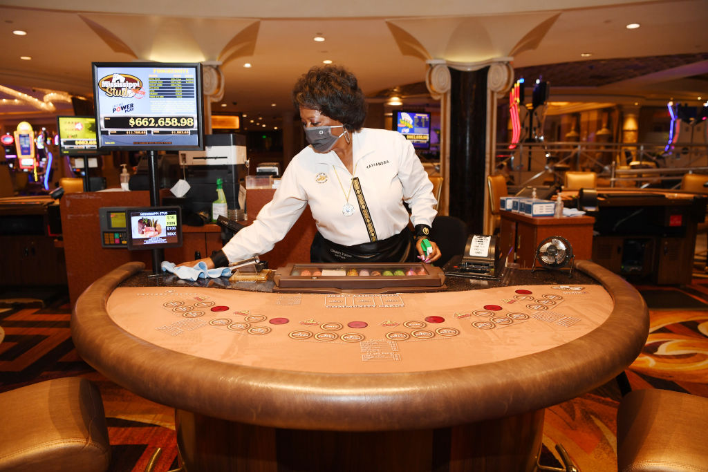 Caesars Palace card dealer Cassandra Williams cleans a card table at Caesars Palace on June 4, 2020 in Las Vegas, Nevada.
