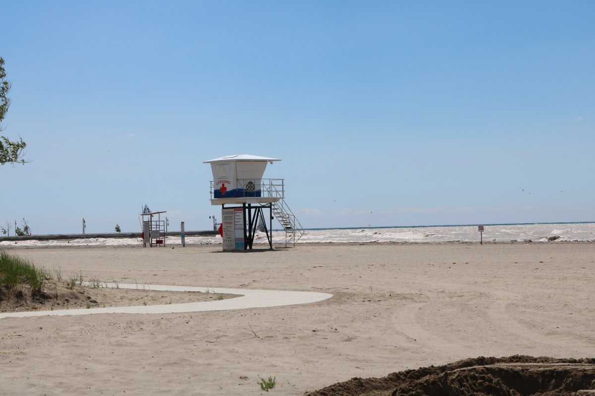 A nearly empty beach with a lifeguard tower.