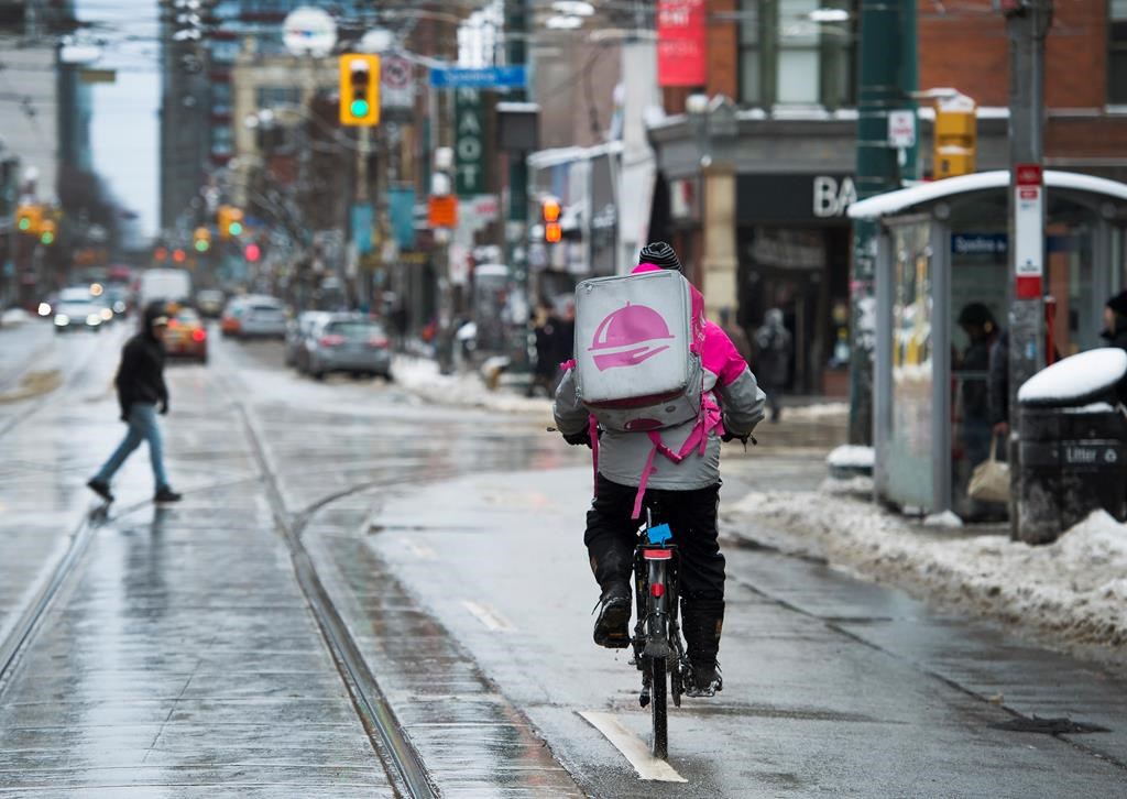 A Foodora courier is pictured as they pick up an order for delivery from a restaurant in Toronto on February 27, 2020. An overwhelming majority of Foodora couriers in Toronto and Mississauga voted in favour of unionizing months before the delivery app exited Canada. The Canadian Union of Postal Workers says 88.8 per cent of the couriers in the area threw their support behind unionization. The union is sharing the number because the Ontario Labour Relations Board recently unsealed and counted ballots nine months after a certification vote asked couriers last August if they wanted to unionized with CUPW. THE CANADIAN PRESS/Nathan Denette.