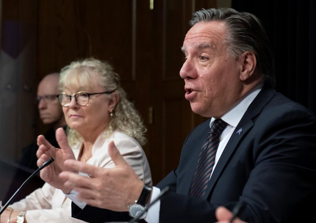 Quebec Premier Francois Legault speaks during a news conference on the COVID-19 pandemic, Tuesday, June 2, 2020 at the legislature in Quebec City. Quebec Minister Responsible for Seniors and Informal Caregivers Marguerite Blais, left, looks on.