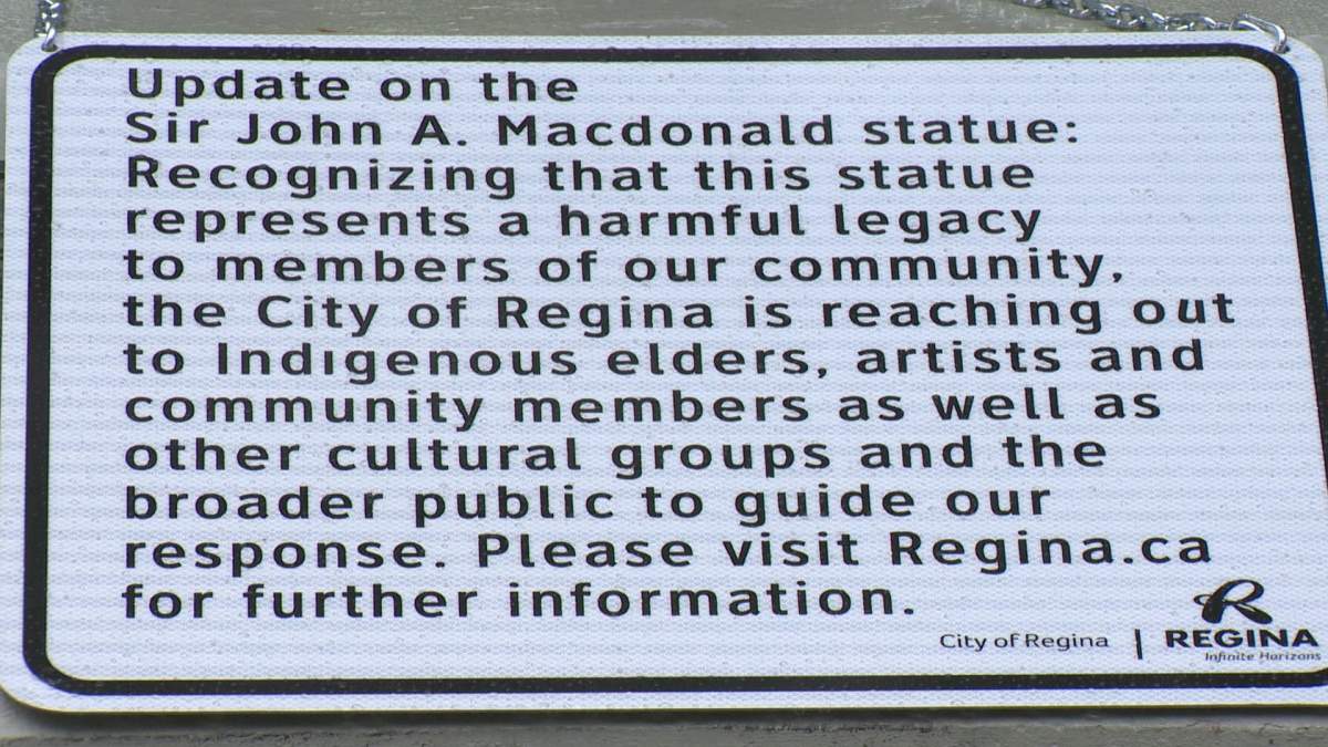 Signage regarding the legacy review hangs from the John A. Macdonald statue in Victoria Park.