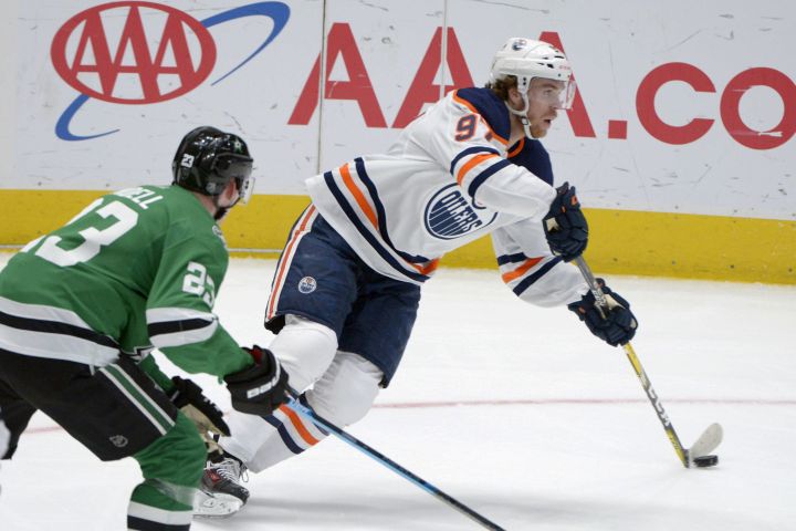 Edmonton Oilers centre Connor McDavid (97) controls the puck next to Dallas Stars defenceman Esa Lindell (23) during the second period of an NHL hockey game in Dallas, Tuesday, March 3, 2020.