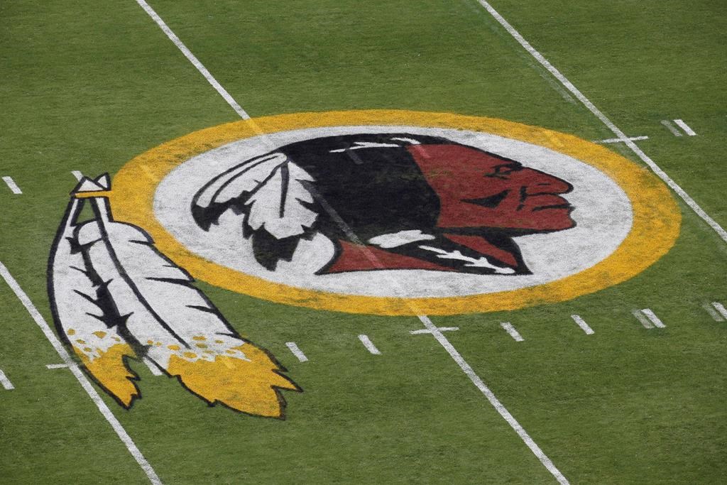 FILE - In this Aug. 7, 2014 file photo, the Washington Redskins NFL football team logo is seen on the field before an NFL football preseason game against the New England Patriots in Landover, Md. The recent national conversation about racism has renewed calls for the Washington Redskins to change their name. D.C. mayor Muriel Bowser called the name an "obstacle" to the team building its stadium and headquarters in the District, but owner Dan Snyder over the years has shown no indications he'd consider it.