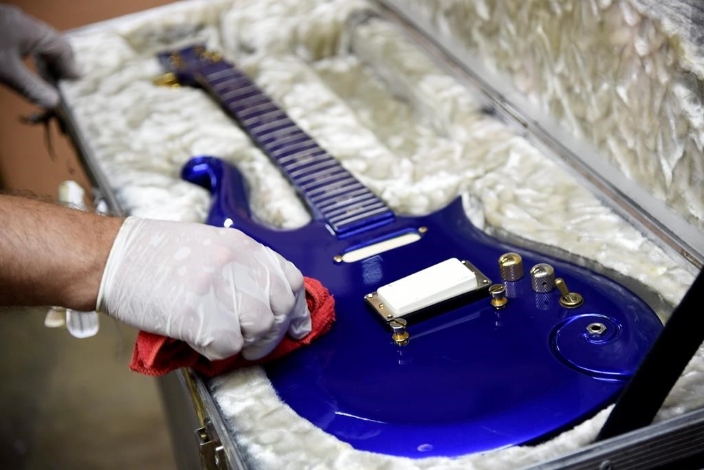 FILE - In this May 6, 2020 file photo, the “Blue Angel” Cloud 2 electric guitar custom-made for the musician Prince in the 1980s is polished at Julien's Auctions warehouse in Culver City, Calif. On Friday, June 19, 2020, the instrument shot past the top estimate of $200,000 it was expected to fetch at the Music Icons sale at the auction house. (AP Photo/Chris Pizzello).