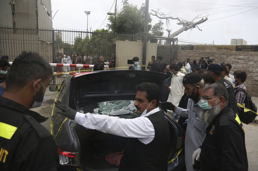 Security personnel check a car used by attackers at the Stock Exchange Building in Karachi, Pakistan, Monday, June 29, 2020.