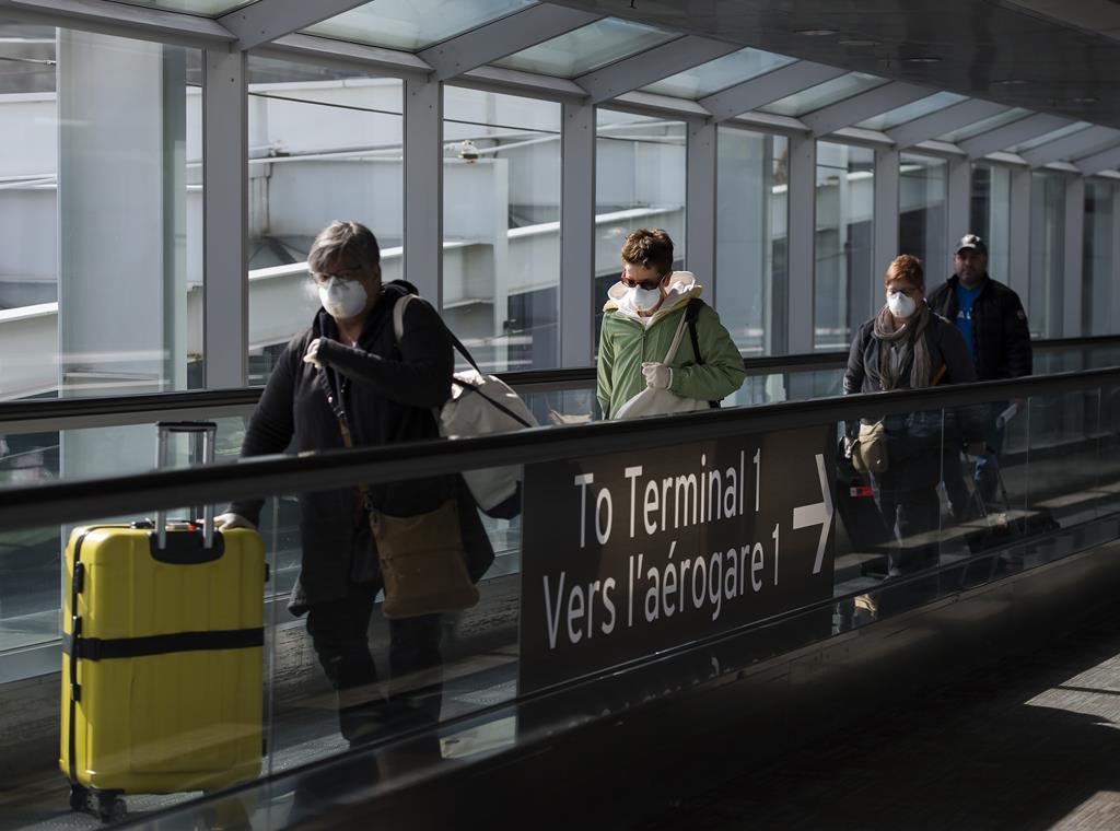 People leave the terminal after arriving at Pearson International Airport in Toronto on Monday, March 16, 2020.