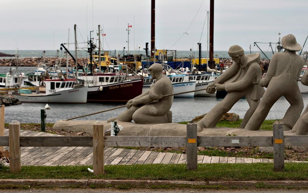 A sculpture shows fishermen pulling on a line in front of the marina, Monday, August 6, 2012 in L'Étang du Nord on the Magdalen Islands.