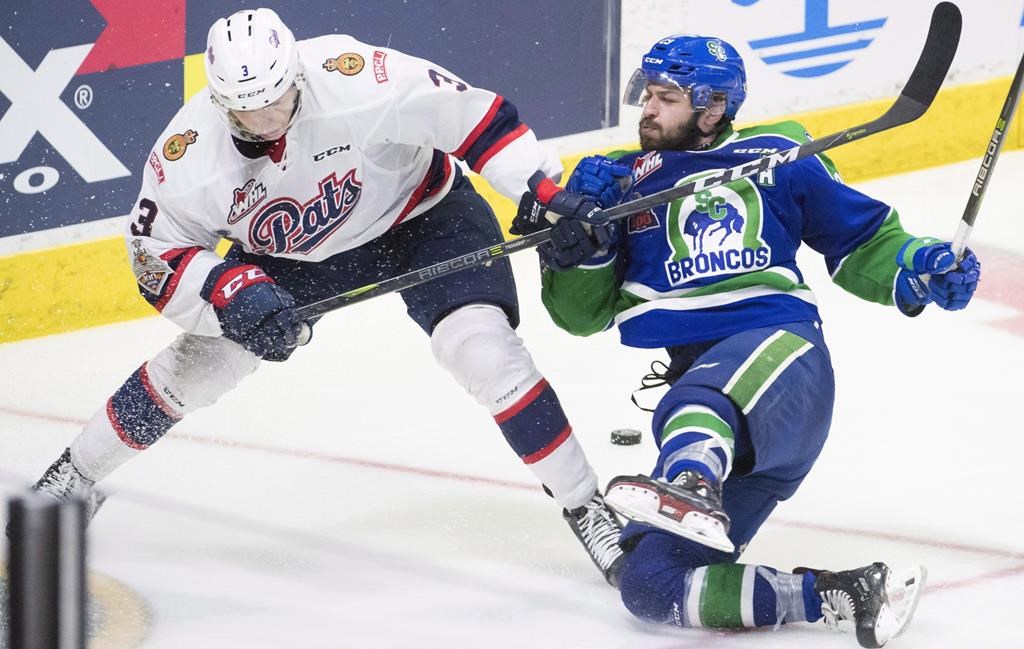 Regina Pats defenceman Libor Hajek (3) fights for control of the puck with WHL Swift Current Broncos forward Tanner Nagel (25) during third period Memorial Cup action in Regina on Wednesday, May, 23, 2018. Western Hockey League teams need at least 50 per cent of their fans in their arenas next season in order to operate, according to the league commissioner. THE CANADIAN PRESS/Jonathan Hayward.