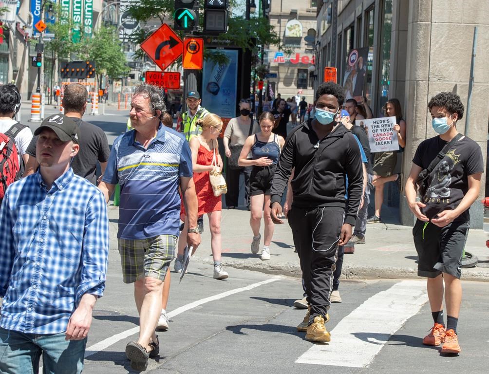 Pedestrians walk on Ste. Catherine street Thursday, June 18, 2020 in Montreal. Many Montrealers are still not wearing face masks as the government strongly recommends. THE CANADIAN PRESS/Ryan Remiorz.