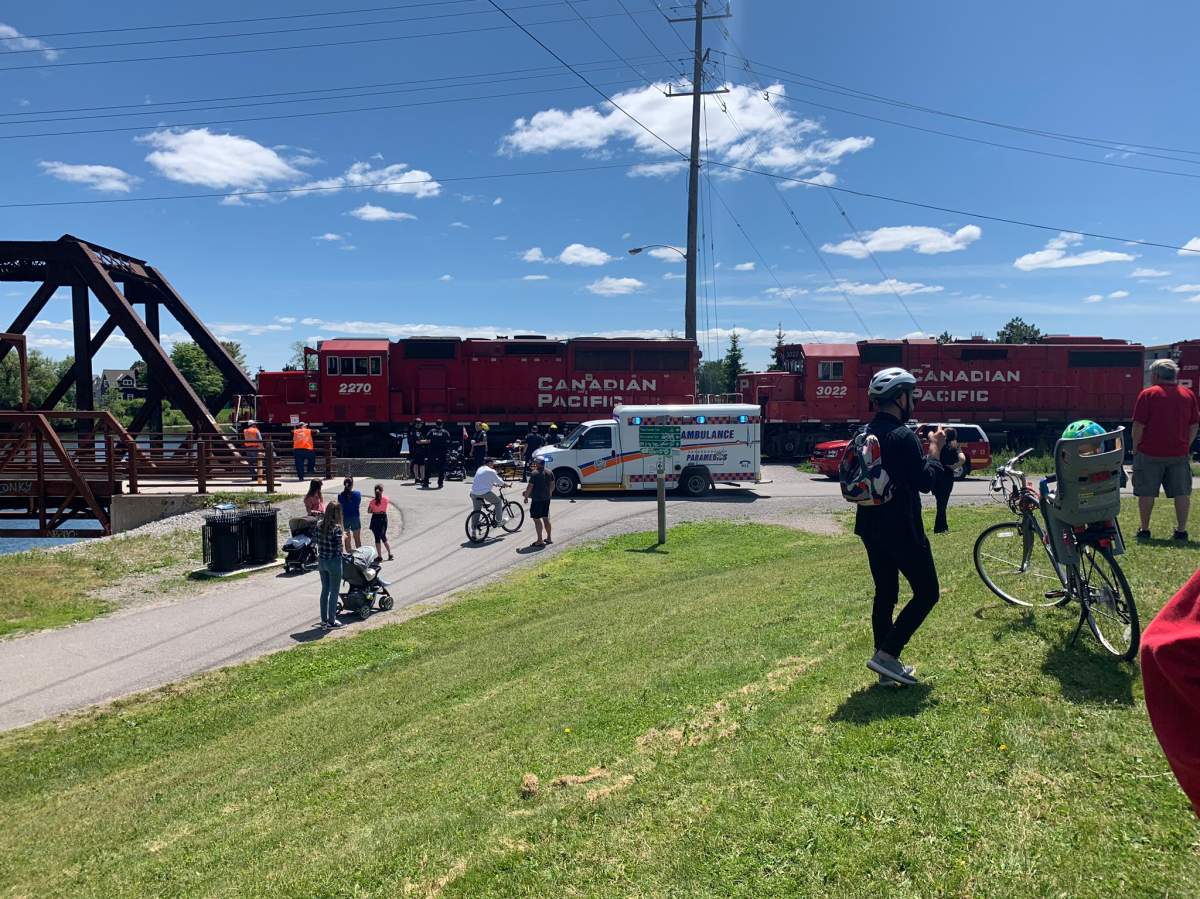 Paramedics tend to a man who was on a scooter when it was struck by a train in Peterborough on Sunday.