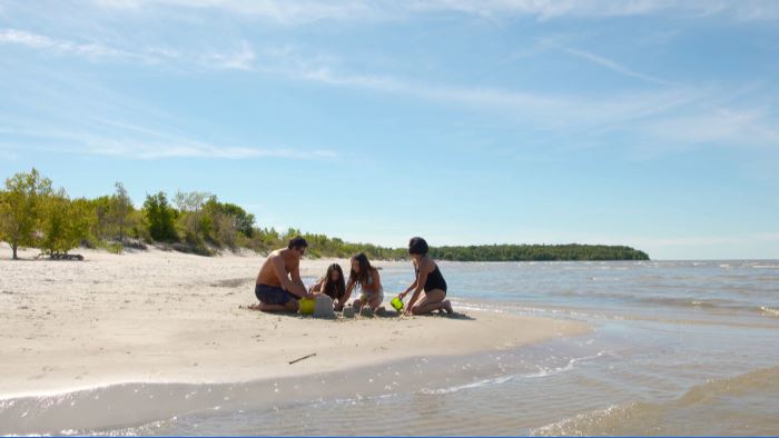 Vacationers enjoying some time in the sun at a Manitoba beach.