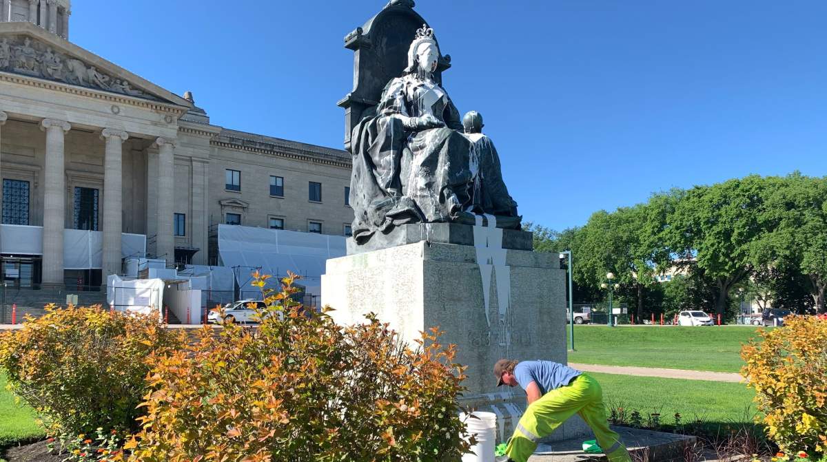 City workers clean up the statue of Queen Victoria in front of the Manitoba Legislature.