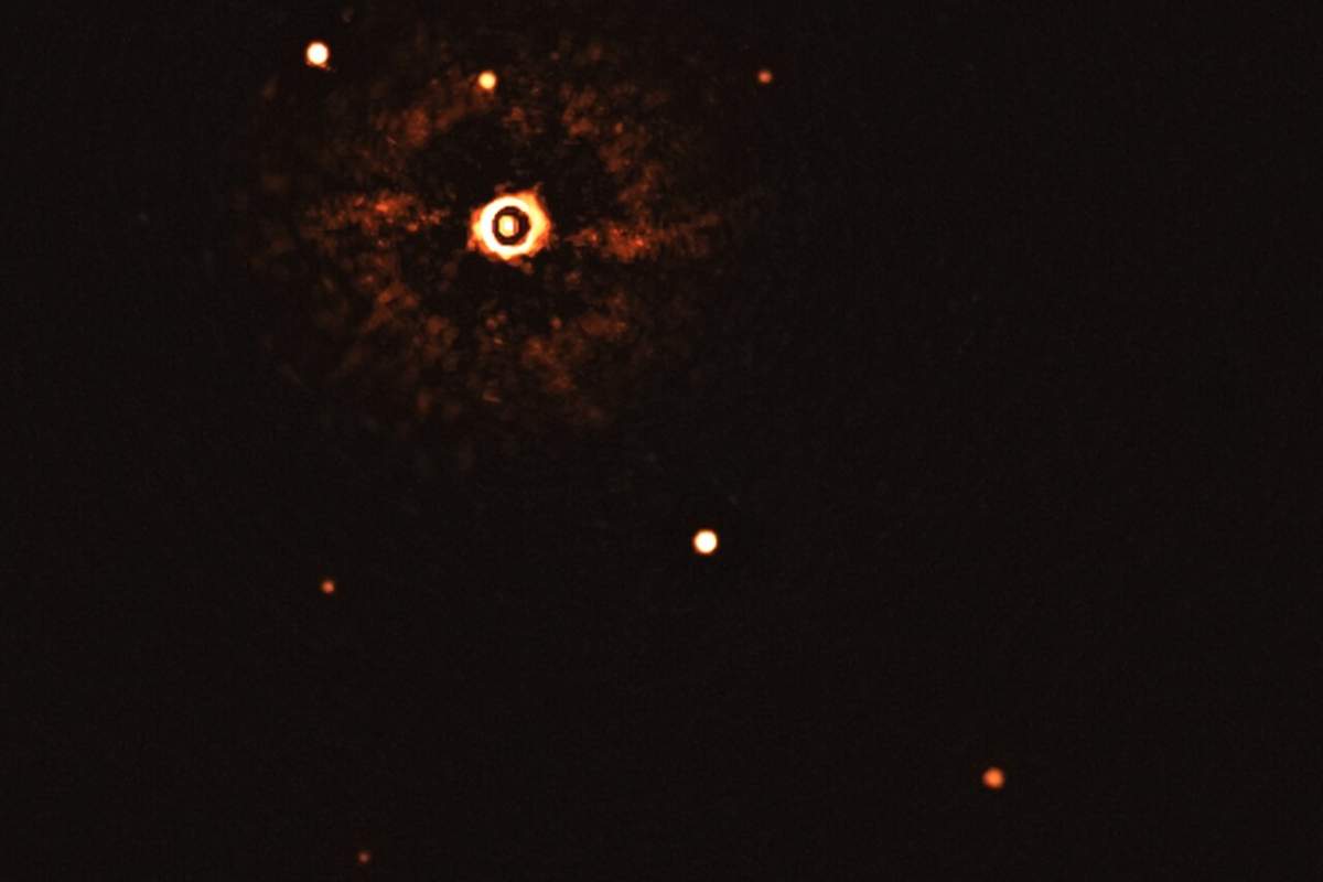 Star TYC 8998-760-1 and two gas giants are shown some 300 light-years away, in the first-ever direct photo of a distant star and multiple exoplanets.