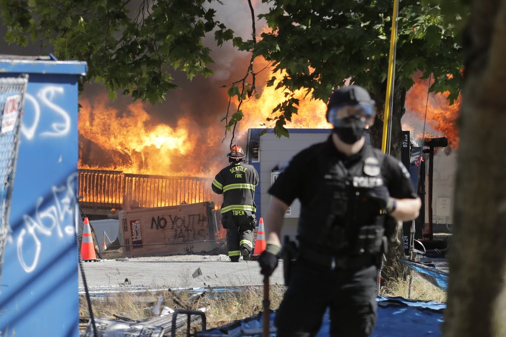 Construction buildings burn near the King County Juvenile Detention Center, Saturday, July 25, 2020, in Seattle, shortly after a group of protesters left the area. A large group of protesters were marching Saturday in Seattle in support of Black Lives Matter and against police brutality and racial injustice. Protesters broke windows and vandalized cars at the facility. 