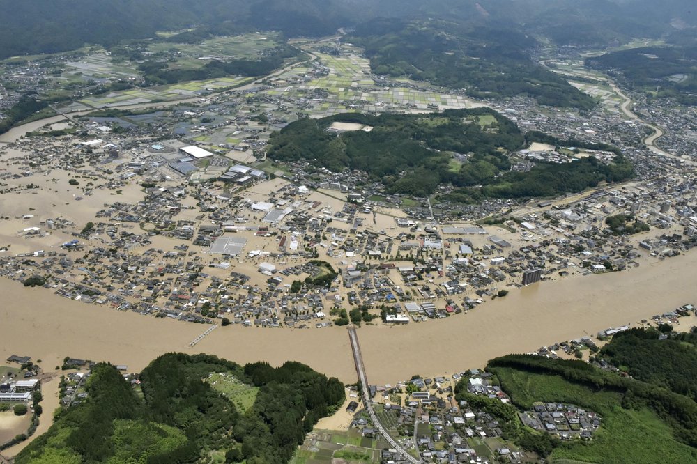 Areas are inundated in muddy waters that gushed out from the Kuma River in Hitoyoshi, Kumamoto prefecture, southwestern Japan, Saturday, July 4, 2020. Heavy rain triggered flooding and mudslides on Saturday, leaving more than a dozen missing and others stranded on rooftops waiting to be rescued. More than 75,000 residents in the prefectures of Kumamoto and Kagoshima were asked to evacuate following pounding rains overnight.