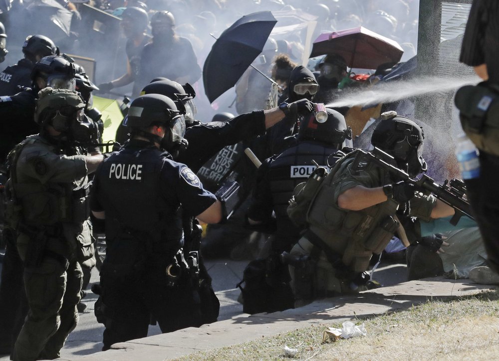 Police pepper spray protesters, Saturday, July 25, 2020, near Seattle Central Community College in Seattle. A large group of protesters were marching Saturday in Seattle in support of Black Lives Matter and against police brutality and racial injustice.