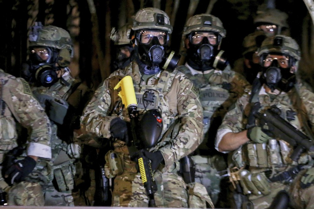Police stand as protesters gather during a demonstration, Thursday, July 16, 2020 in Portland, Ore. Federal officers deployed tear gas and fired less-lethal rounds into a crowd of protesters late Thursday. The actions came just hours after the head of the Department of Homeland Security called the protesters “violent anarchists.” .