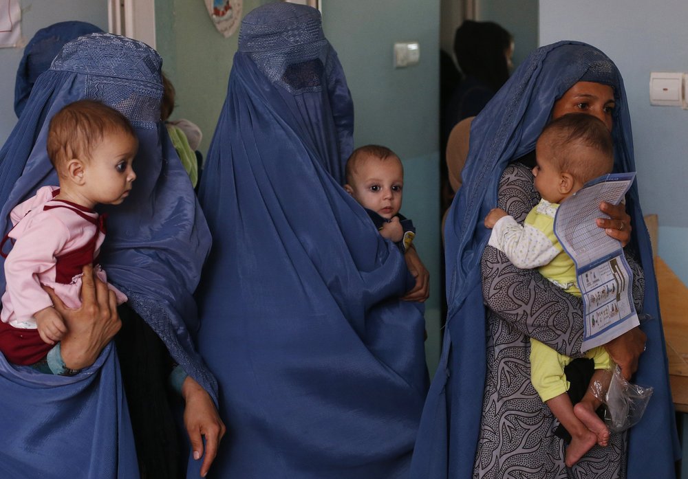 FILE – In this Aug. 26, 2019 photo, mothers hold their babies suffering from malnutrition as they wait at a UNICEF clinic in Jabal Saraj, north of Kabul, Afghanistan. In Afghanistan, severe childhood malnutrition spiked from 690,000 in January 2020 to 780,000 — a 13% increase, according to UNICEF. Food prices have risen by more than 15%, according to the World Food Program.