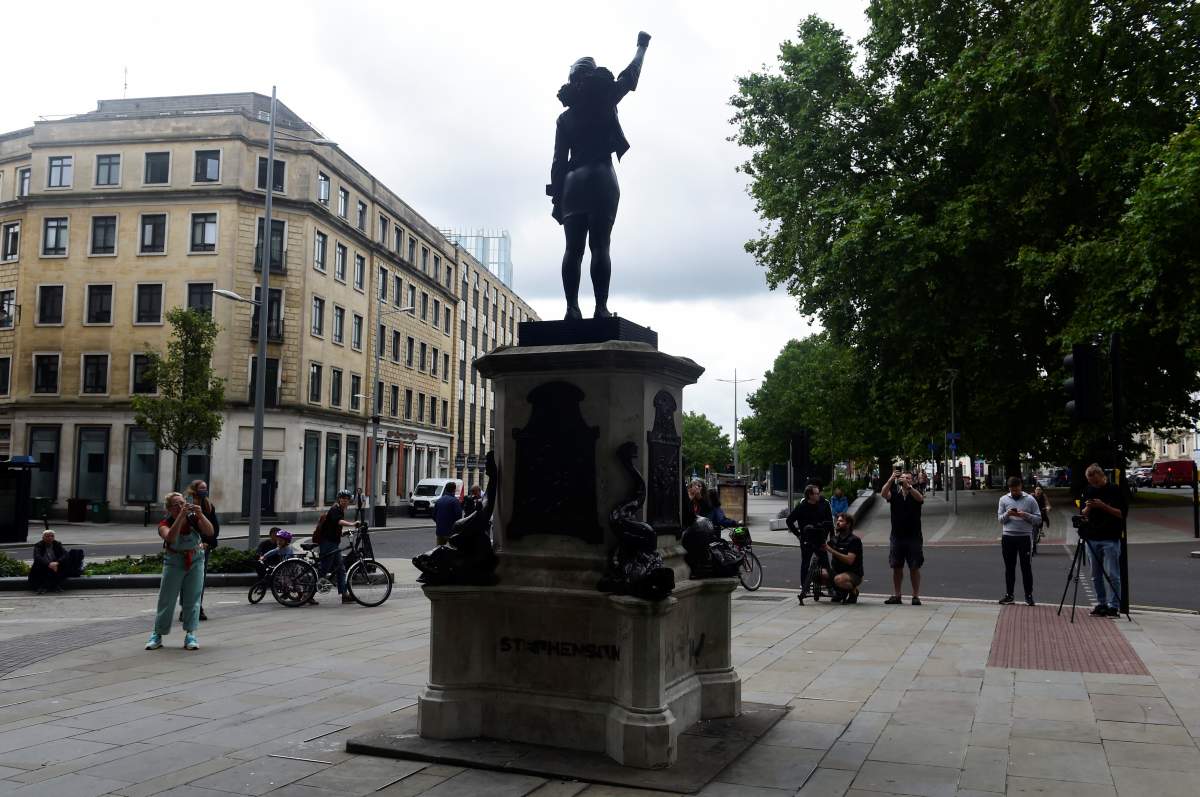 People take pictures of the sculpture of a Black Lives Matter protester standing on the empty plinth previously occupied by the statue of slave trader Edward Colston, in Bristol, Britain, July 15, 2020.