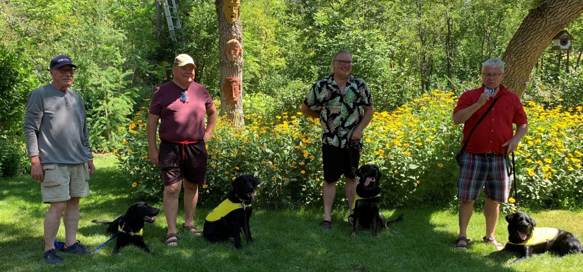 All four future CNIB guide dogs with their raisers.