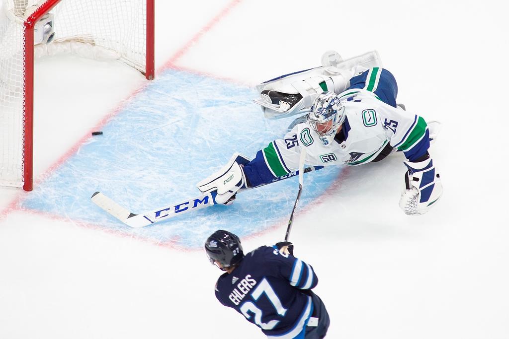 The Winnipeg Jets' Nikolaj Ehlers (27) scores on Vancouver Canucks goaltender Jacob Markstrom (25) during second-period NHL exhibition game action in Edmonton, on Wednesday, July 29, 2020.