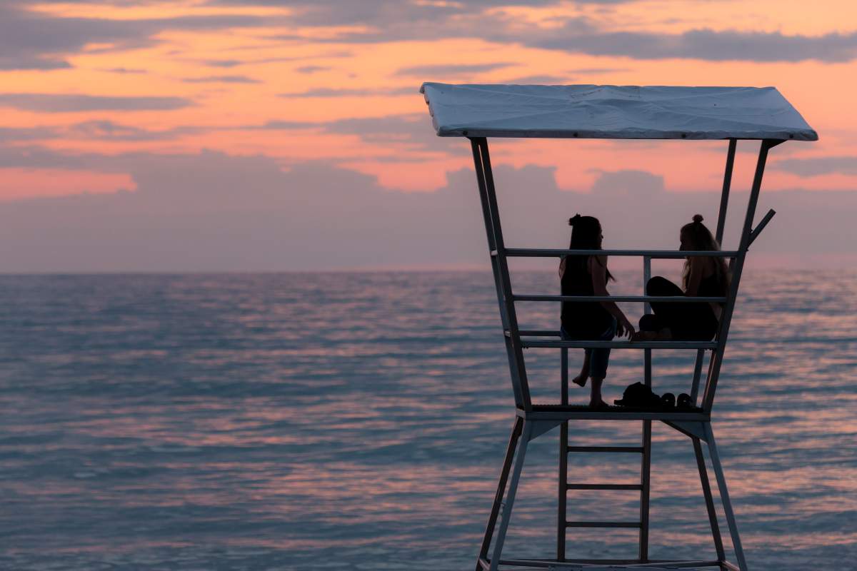 Two young women sit and talk in a lifeguard tower in Grand Bend, Ontario.