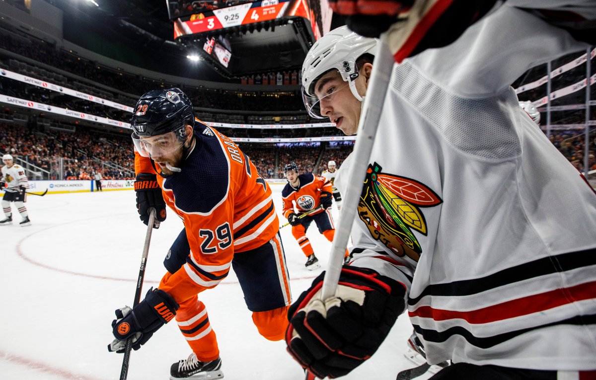 Chicago Blackhawks' Kirby Dach (77) and Edmonton Oilers' Leon Draisaitl (29) battle for the puck during second period NHL action in Edmonton, Alta., on Tuesday February 11, 2020. THE CANADIAN PRESS/Jason Franson.