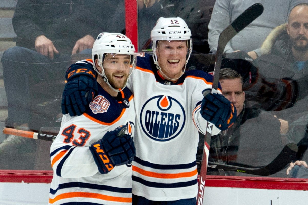 FILE - This Feb. 28, 2019, file photo shows Edmonton Oilers center Colby Cave (12), right, celebrating his goal with teammate Josh Currie during the third period of an NHL hockey game against the Ottawa Senators in Ottawa, Ontario. Colby passed away in April. His widow, Emily, is hoping to inspire the Oilers for their playoff run. 